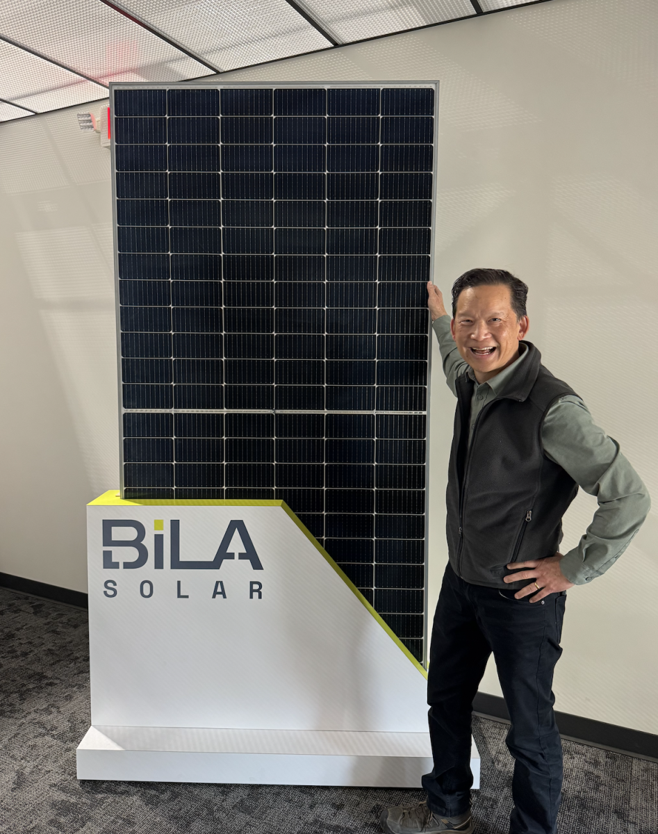 Bila Solar’s Wei Tai Kwok standing in front of a Bila solar panel